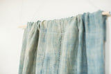 Vintage light blue indigo textile's sun-faded texture and top edge hand-stitching.