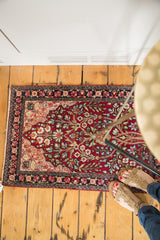 Antique Kerman rug mat with a floral tree of life motif, styled in a home to show scale.