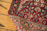 Antique Kerman rug corner folded to show the hand-knotted foundation and tightly woven pile.