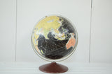 Vintage 1960s Rand McNally 12 inch black globe with colorful continents, brass stand, and wood base.