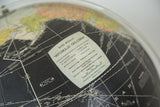 Vintage Rand McNally World Globe label with city data and white navigation lines on the black surface.