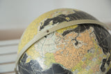 Vintage 1960s Rand McNally black globe with Arctic Ocean and beige landmasses.