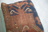 Terracotta and blue tribal patterns with aged texture on antique Kazak rug fragment pillow.