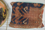 Hand-knotted antique Kazak rug fragment pillow showcasing tribal geometric patterns in rust and blue.