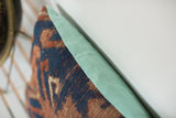 Hand-knotted texture of antique Kazak rug fragment pillow with faded turquoise linen.