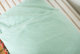 Mint green linen pillow back with envelope enclosure stitching.