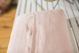 Pale pink European linen back of pillow with envelope enclosure stitching.