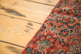 Intricate teal and blue floral motifs on the vibrant ruby red antique Bijar fragment.