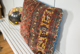 Antique Persian Bijar rug fragment with rich red, yellow, and blue border patterns.