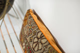 Close-up of vintage floral Caucasian rug fragment's textured weave with tangerine velvet.