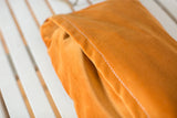 Vintage tangerine orange velvet pillow back with white zig-zag enclosure stitching.