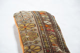 Angled view of Vintage Floral Caucasian rug fragment pillow side with tangerine velvet.