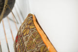 Hand-knotted vintage floral rug fragment pillow with warm earth tones and tangerine velvet.