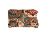 Antique Kazak rug fragment pillow with geometric stars, rich terracotta, blue, and cream, 12x20.