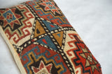 Hand-knotted pile with bold geometric patterns on the antique Kazak fragment pillow.