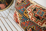 Bold geometric design in rust, sapphire blue, and gold on antique Kazak fragment pillow.