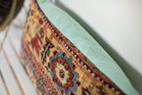 Antique Bijar rug fragment pillow border with intricate ivory, yellow design and faded turquoise linen.