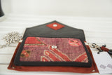Open rug fragment purse with textured purple and red Northwest Persian textile and button.