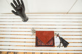 Reddish-brown suede rug fragment purse with striking vintage Persian purple and red pattern.