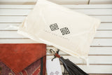 Swag and Tassel brand cream dust bag, embossed red-brown suede purse flap, and black leather tassel.