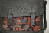 Swag and Tassel logo on leather flap over antique geometric Kazak rug fragment.