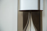 Close-up of Tucker lamp's black acrylic base and white shade with copper-toned rim.