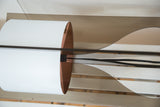 Curved white shade of the Tucker lamp showing wood veneer interior and black cord.