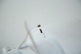 Detail of the vintage white desk lamp's dark adjustment screw and threaded post.