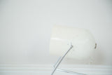 Close-up of Mid Century spotlight lamp showing chipping white paint and chrome stand.