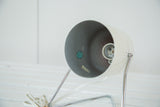 Mid Century spotlight lamp's bulb socket, interior label, and chipped white paint.