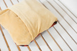 Soft gold velvet envelope back of pillow with colorful rug fragment hint.