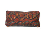 Antique Afghani rug fragment lumbar pillow, red-orange with geometric blue diamond pattern.