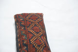 Textured antique Afghani rug pillow showing deep red, navy, and orange diamond patterns.