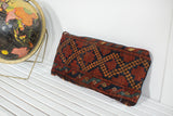 Antique Afghani rug fragment pillow with rich terracotta and navy geometric diamond design.