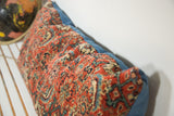 Close-up of the intricate Persian Bijar rug fragment texture in rustic red and teal.