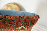 Detail of Antique Bijar lumbar pillow, intricate red, blue, cream rug pattern, blue edge.