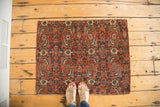 Antique Bijar fragment rug's intricate hand-knotted pattern in bold red, blue, and cream with secured edges.
