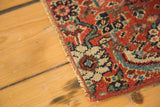 Secured edge and intricate floral-geometric motifs of the bold red antique Bijar rug fragment.