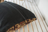 Black European linen pillow back with white zigzag stitching and antique Turkmen fragment.