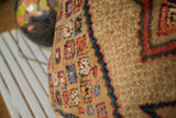 Plush camel hair floor pillow showcasing colorful red, blue, and green geometric Serab motifs.
