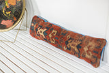 Antique Caucasian Kazak fragment pillow, rust and muted blue geometric patterns, cobalt edge, 6x23x3.