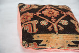 Angled close-up of antique Northwest Persian pillow, charcoal ground, peach pattern, linen side.