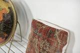 Antique Heriz rug fragment pillow, with time-softened red, beige, and blue woven texture.