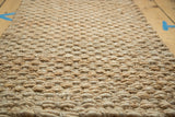 Durable braided natural fibers forming the gold hand woven entrance mat.