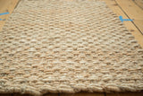 Natural hemp and jute fibers form the hand-braided surface texture of the gold mat.