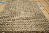Close-up of the hand-braided beige entrance mat's natural fiber surface texture.