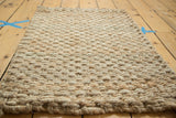 Durable hand-braided texture of an ivory entrance mat, woven from natural fibers.