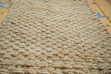 Hand-braided texture of the ivory natural fiber entrance mat.