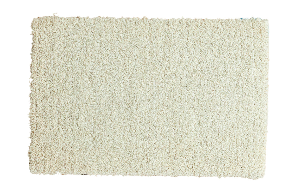 Hand woven cream Moroccan shag bath rug with plush texture, 1'9" x 2'8".