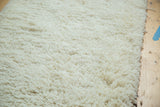 Plush, deep off-white shag pile texture of the bath mat.
